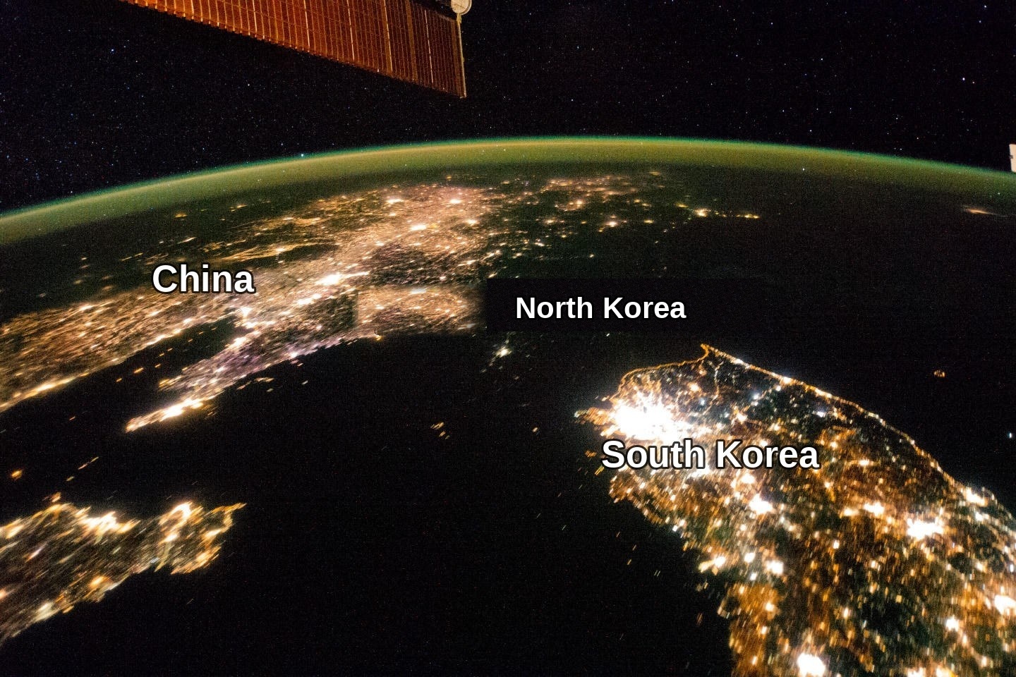 Satellite photograph at night: China and South Korea brightly lit, North Korea almost dark