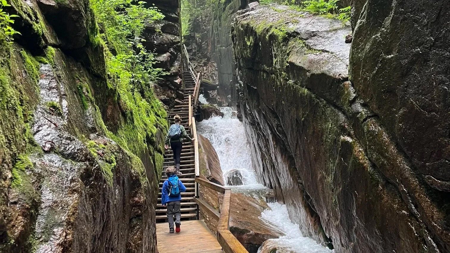 Hikers on the wooden walkway through Flume Gorge