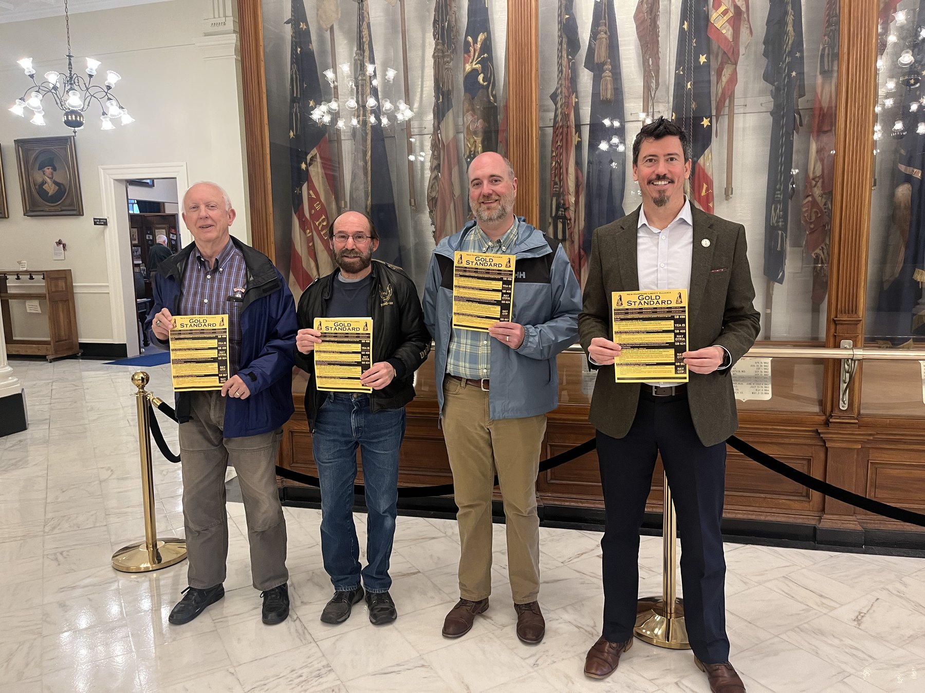 Pedro Serra and three others holding Gold Standard flyers in the New Hampshire State House