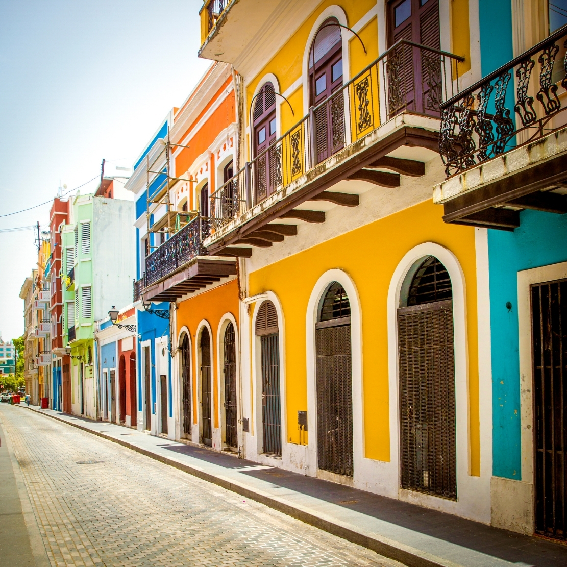 A sunlit cobblestone street of colorful colonial buildings in Old San Juan, Puerto Rico